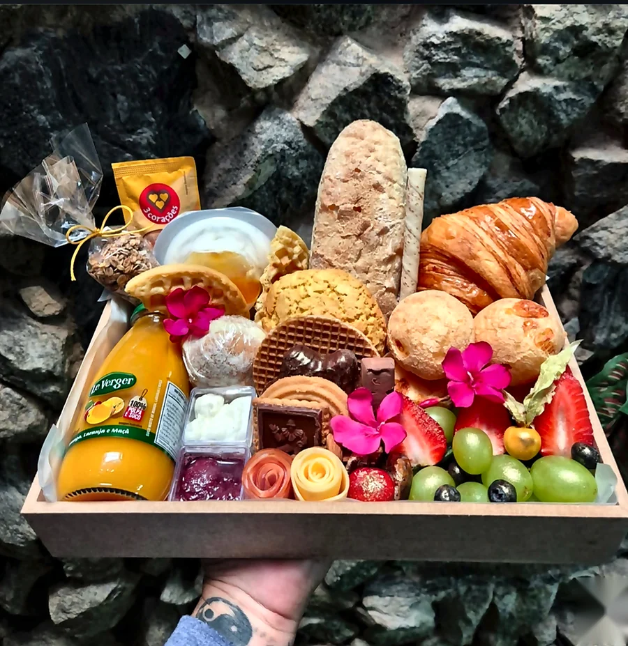 Cesta de café da manhã tradicional com pães, frutas, suco e doces