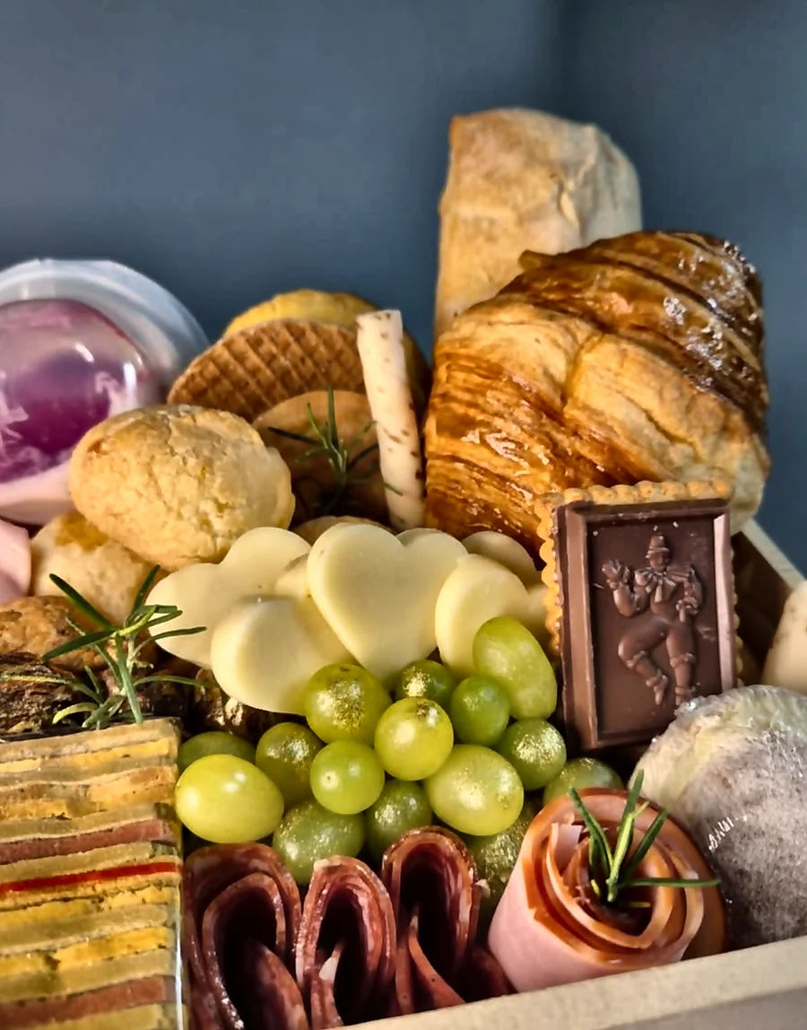 Detalhes de croissant, queijos, frios e frutas