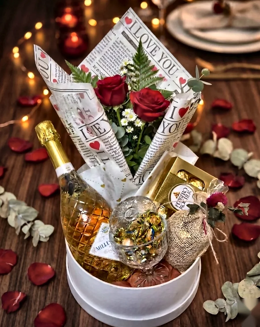 Presente romântico com flores, bebida e chocolates